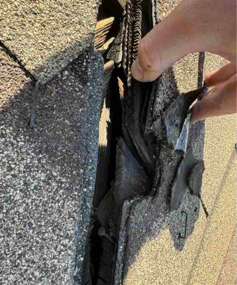 A roofer inspecting a damaged shingle roof in Southern California